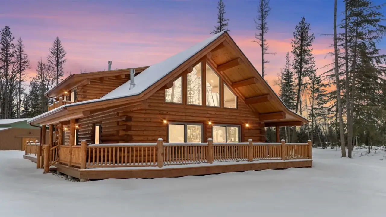Meadowlark Chalet exterior in snow at dusk, Meadowlark Log Homes