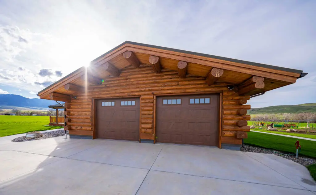 Log home style garage in a scenic rural setting with sunlight
