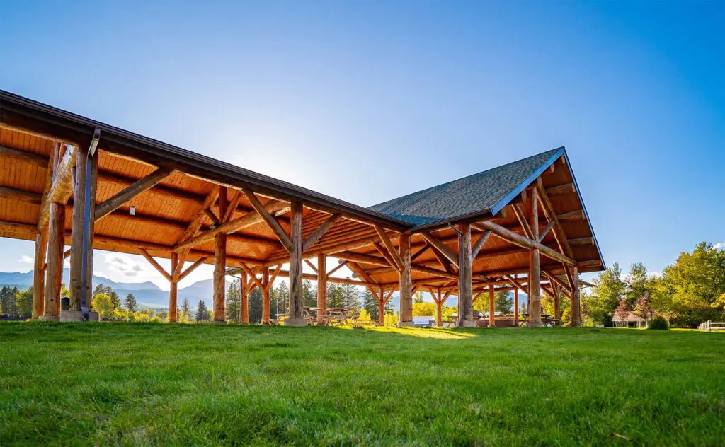 Wooden pavilion structure in a sunny green park setting