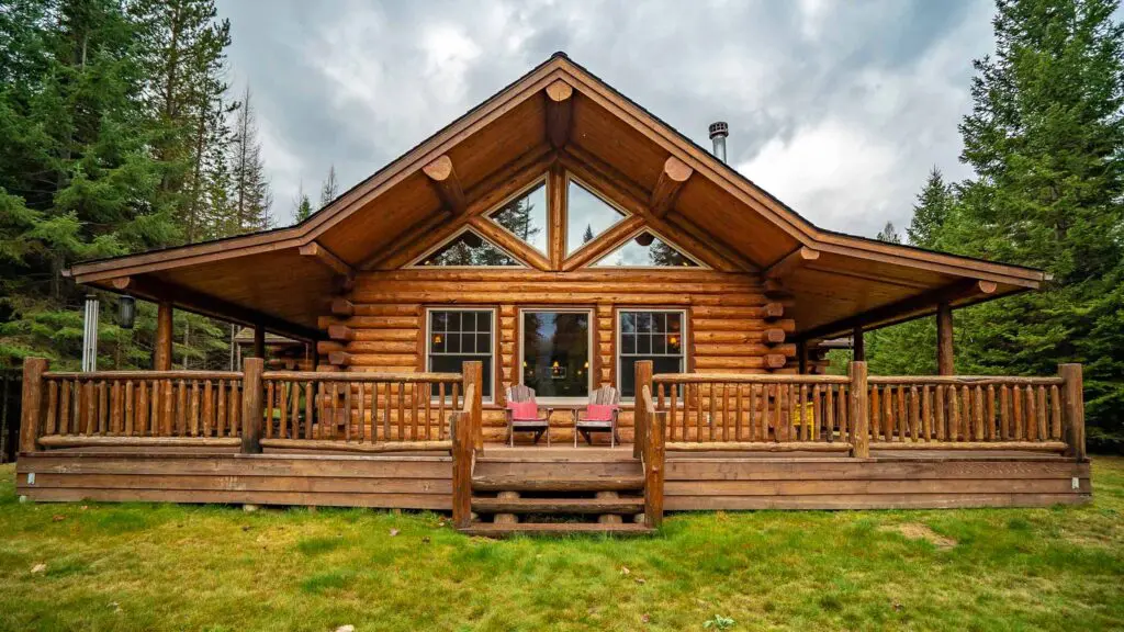 Wooden cabin in a forest setting with a cozy porch