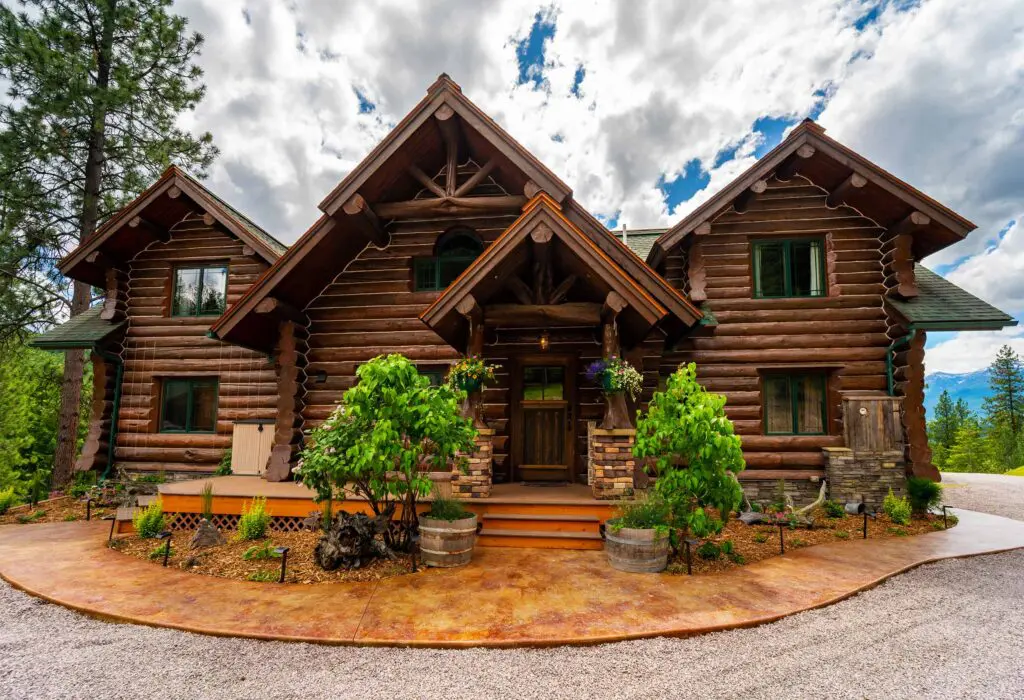 Rustic log home surrounded by trees against a cloudy sky