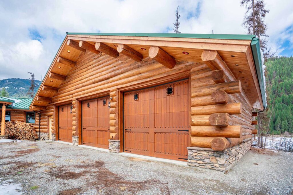 Wooden log cabin garage with scenic forest backdrop
